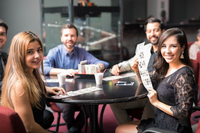 people at table playing bingo with tickets